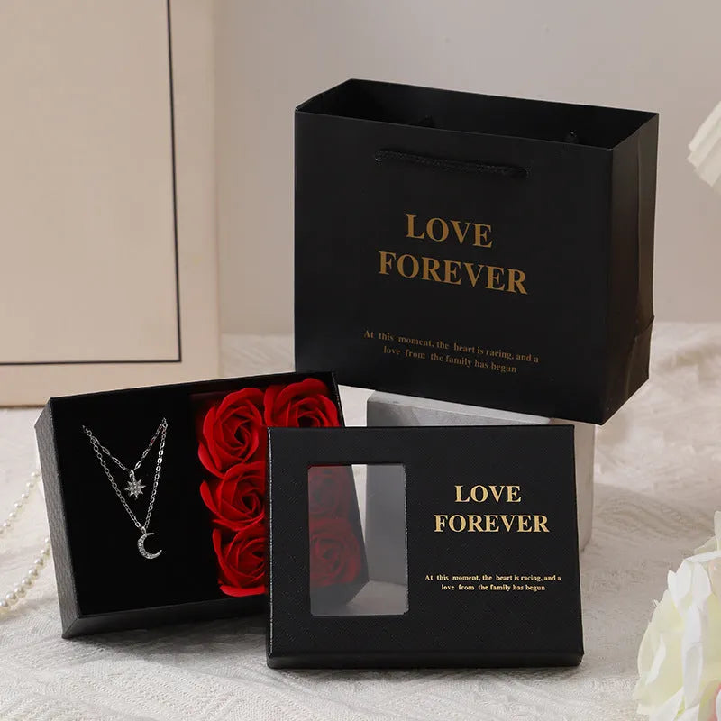 Red Korean style gift box open to show six pink soap flowers, with a matching handbag, for Valentine's Day.