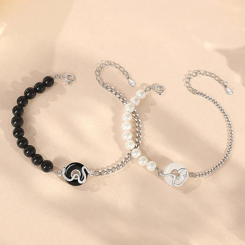 925 sterling silver couple bracelet with snake design and safety buckle on a wrist.