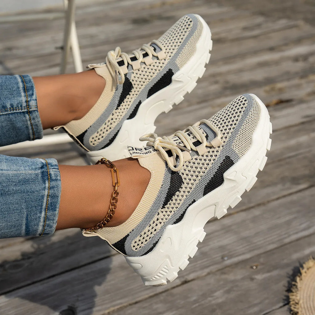 Women's Flyknit mesh lace-up sneakers in a colour option, showing the round toe and rubber sole.