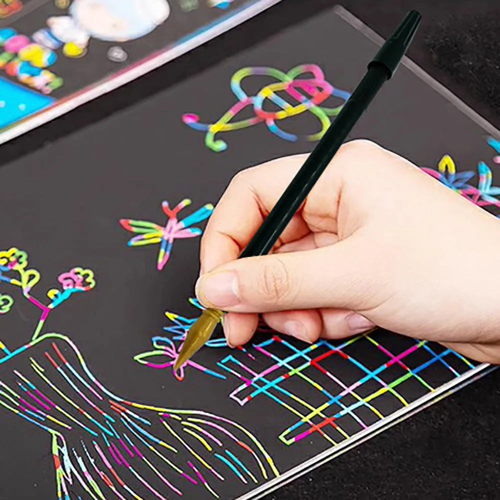A white scratch art pen with a black brush tip on a wooden surface.