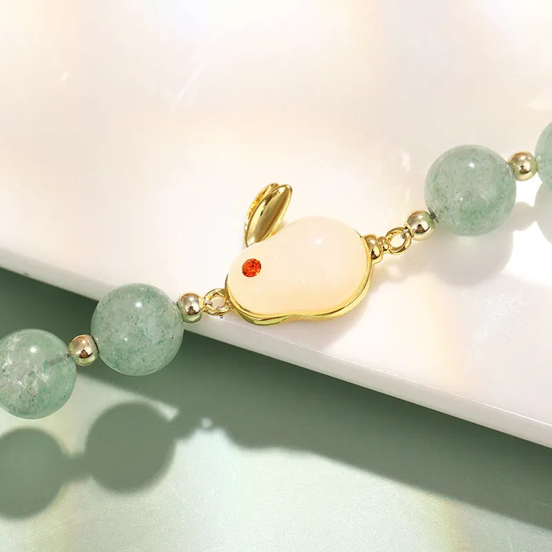 Rabbit charm bracelet with green aventurine and strawberry quartz stones on a gold plated copper chain