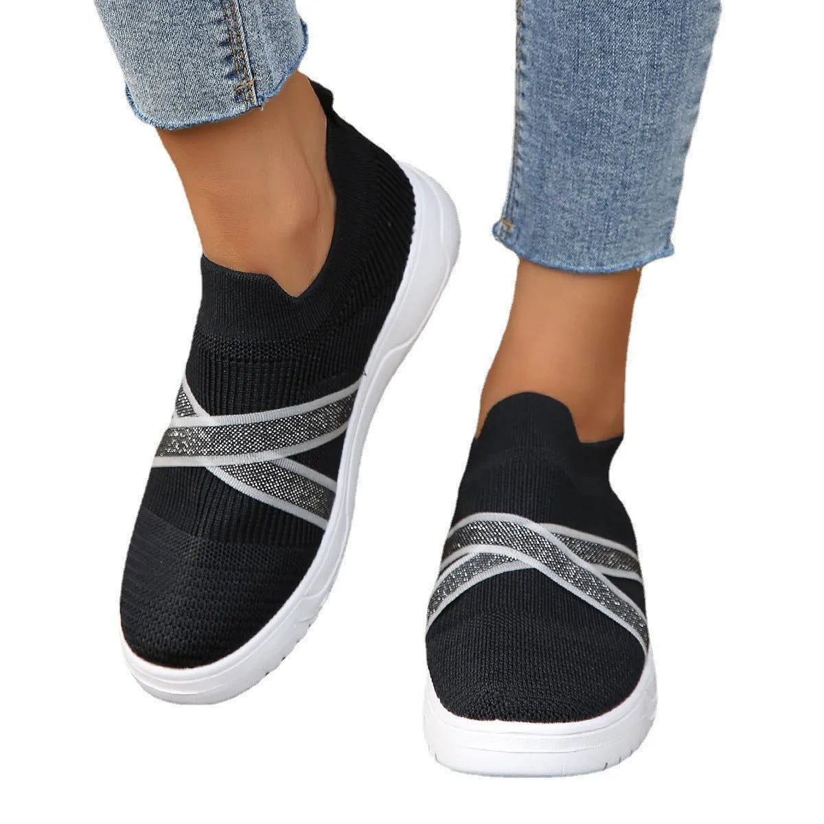 Black women's flat shoes with flyknit mesh upper, round toe, tassel detail, and rubber sole.
