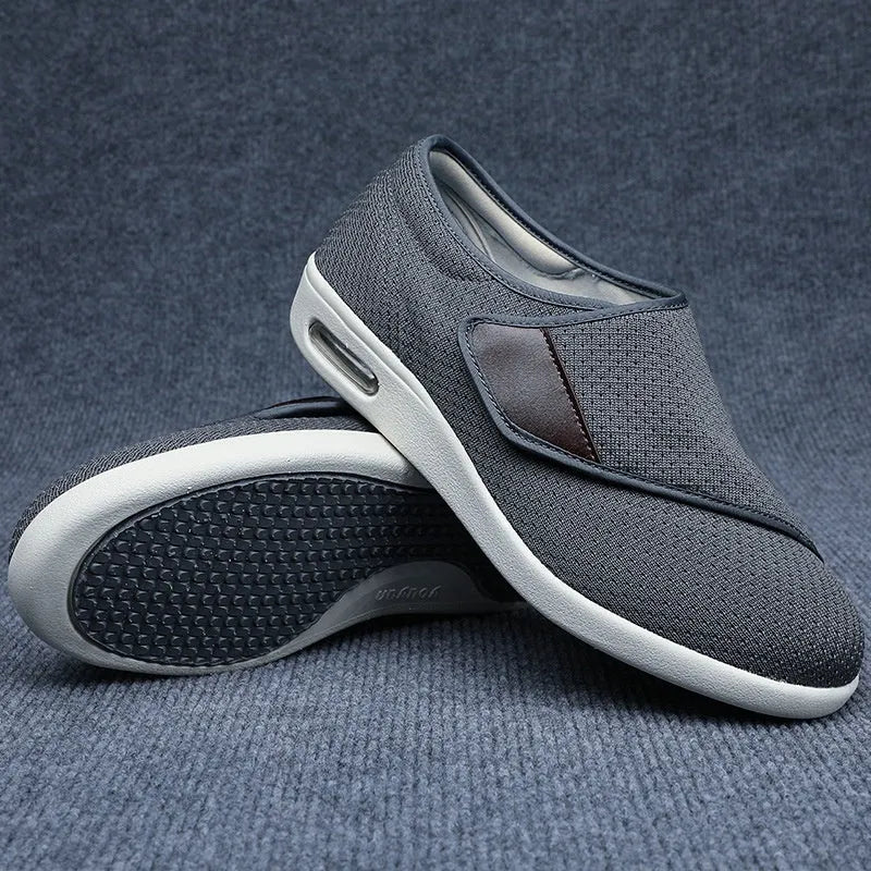 Beige wide-fit leisure shoes with velcro strap and rubber foam sole on a neutral background.