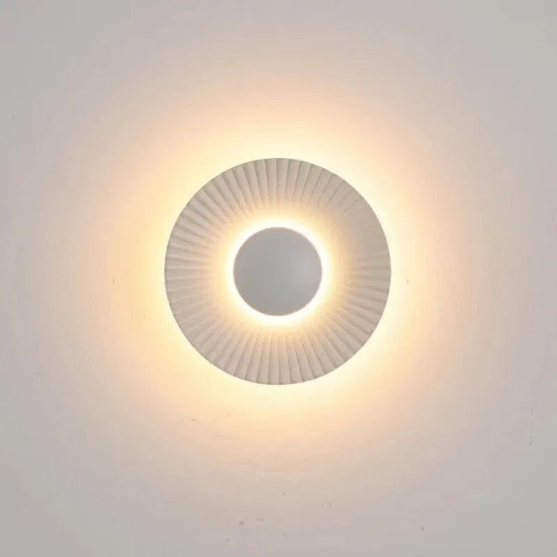 Round aluminium wall lamp mounted on a wall, showing LED illumination.