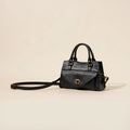 Genuine leather one-shoulder crossbody bag in solid colour with lock closure, horizontal square shape, and visible sewing thread details.