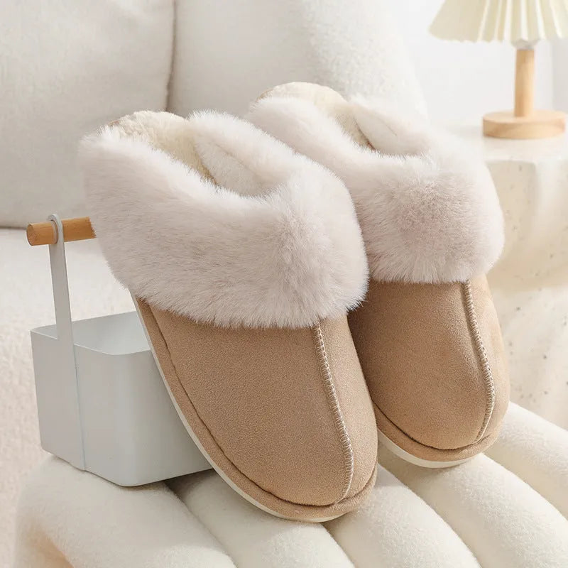 Women's plush winter slippers in pink with a round toe, flat heel, and decorative stitching.