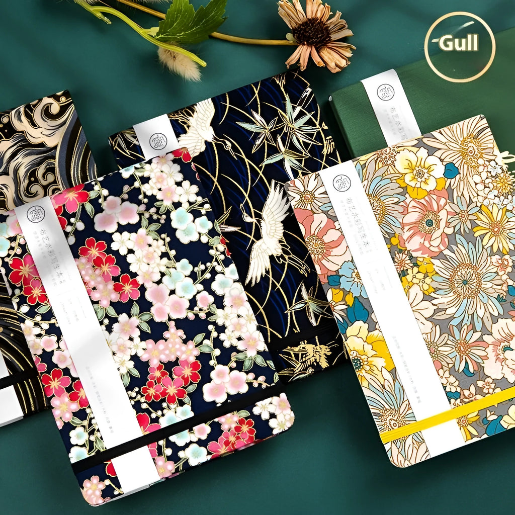 Feiluniao handmade fabric watercolour notebook open on a table with paints, showing a decorative cover.