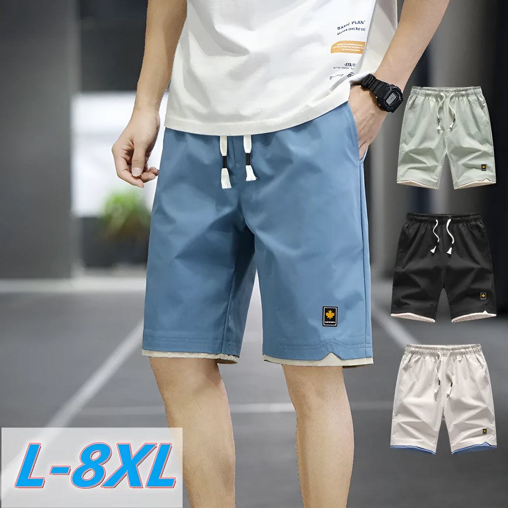 Man wearing straight loose fit beach shorts in 8905 green, made from micro elasticity polyester fabric.
