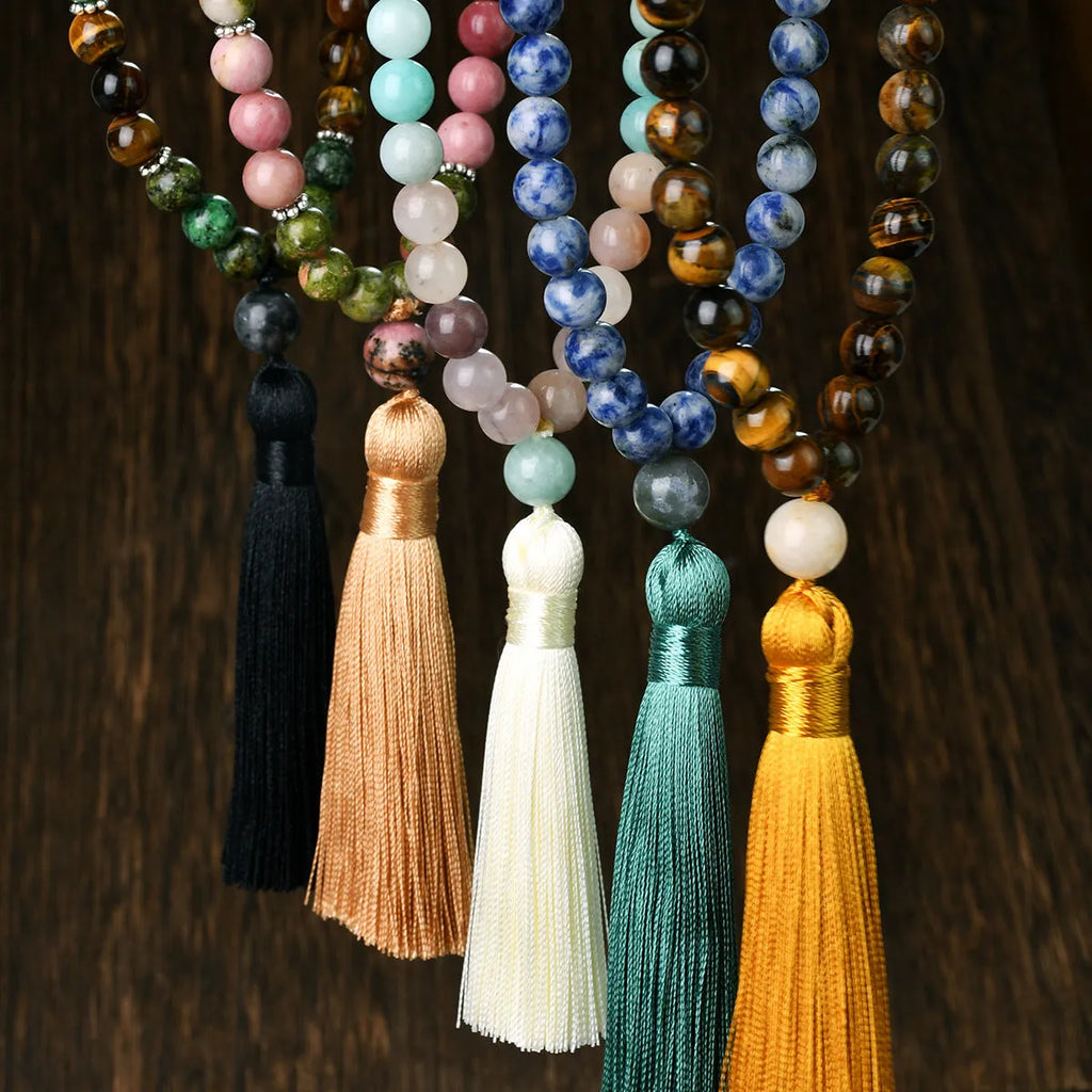 Long 108-bead natural stone necklace with colour-matched tassels and a geometric gem-inlaid pendant on a ball bead chain.