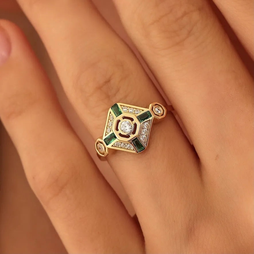 Square-shaped green emerald diamond fashion ring in ins style on a plain background.
