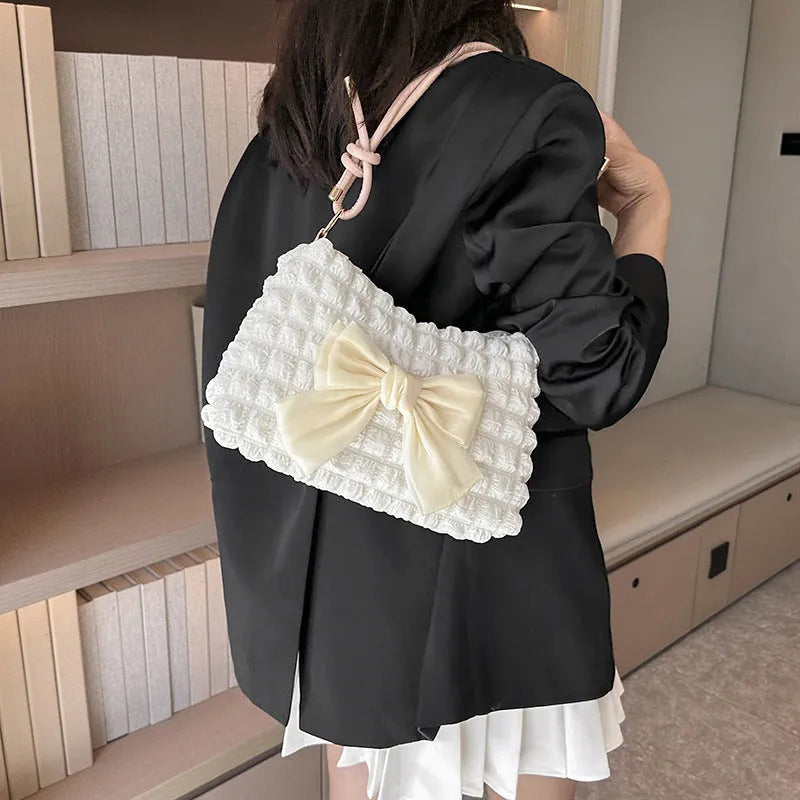 Women's black canvas one-shoulder handbag with a single strap and external sandwich pocket.