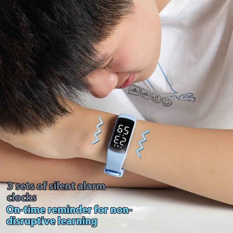 Vibration alarm clock smartwatch with a coloured silicone strap on a wrist, showing its LED display.