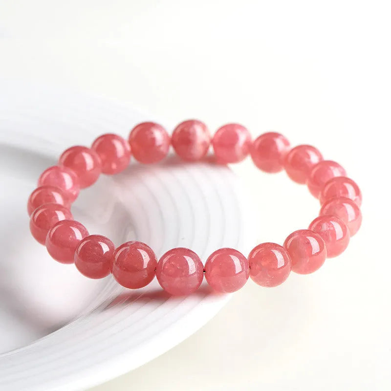 Women's geometric rhodochrosite crystal bracelet with a Longevity Lock design on red beads.