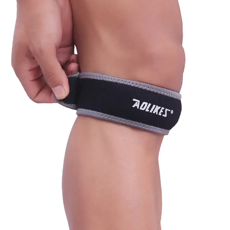 Black and grey patella retinaculum knee support for sports, showing wrap-around design.
