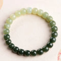Natural Hetian jade bracelet showing gradient water colour and polished oval beads.