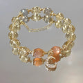 Gold electroplated women's crystal bracelet with diamond shape and fortune charm.