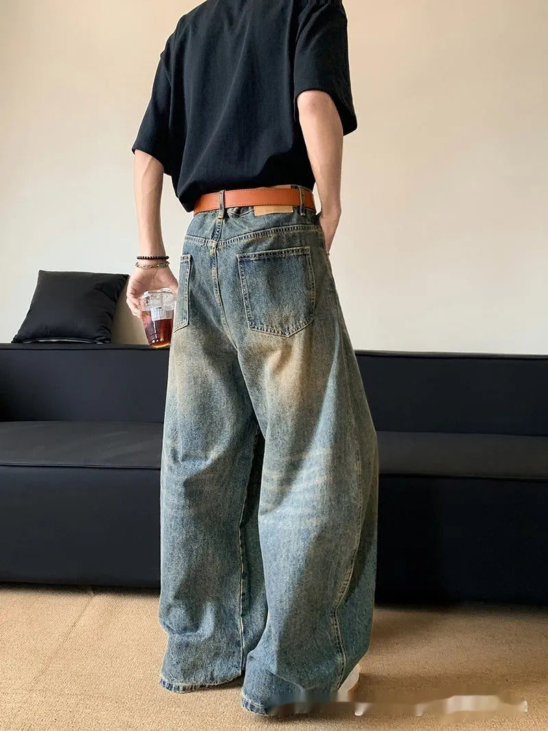 Men's retro blue distressed denim wide-leg trousers showing slim fit and vintage detailing