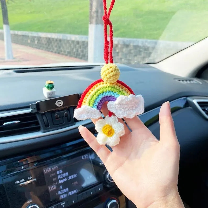 Handmade crocheted car pendant featuring a colourful avocado and rainbow flower design in wool yarn.