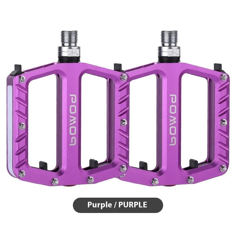 Aluminium alloy bicycle pedals with 710 LED lights in purple, black, titanium, red, and gold colours.