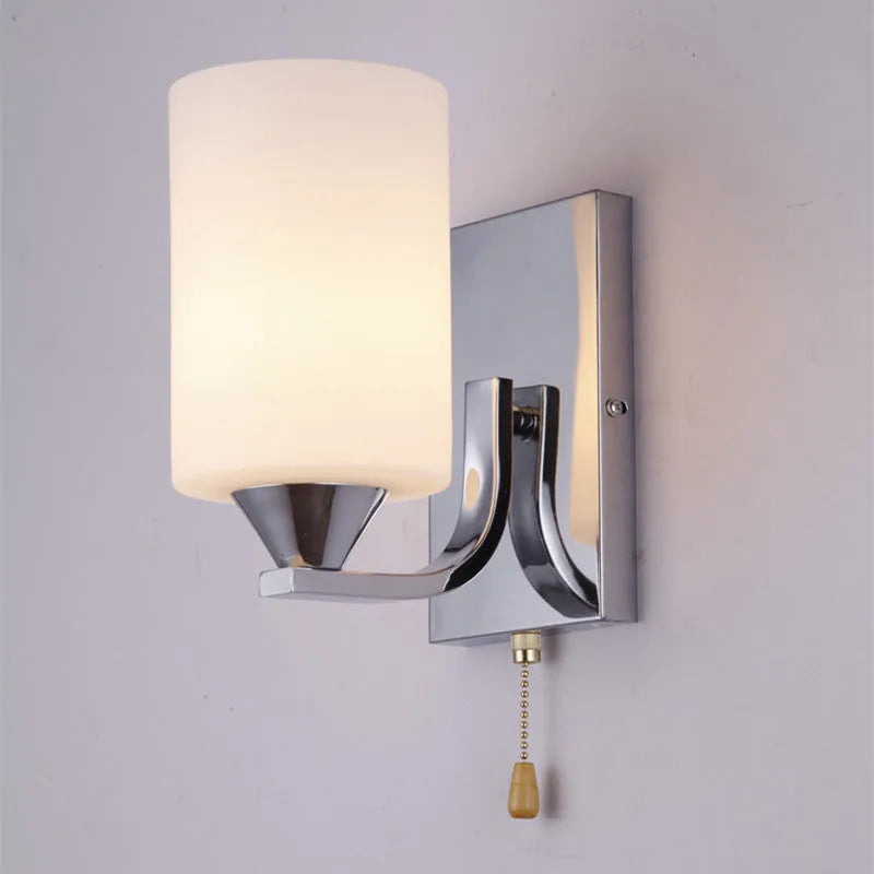 Chrome-finished wall lamp with glass shade in single head and double head configurations.