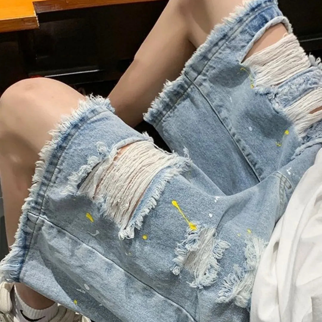 Men's loose fit denim shorts with water washed finish and distressed holes in light blue colour