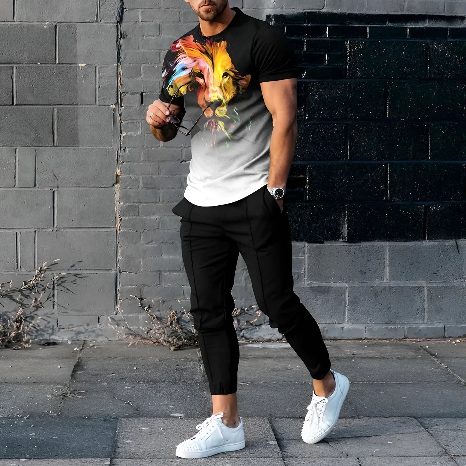 Man wearing a short sleeve printed pullover and matching trousers from a men's two-piece sports set.