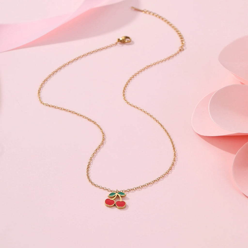 Cherry motif stainless steel jewellery set with gold plating, showing necklace, bracelet, earrings, and ring.