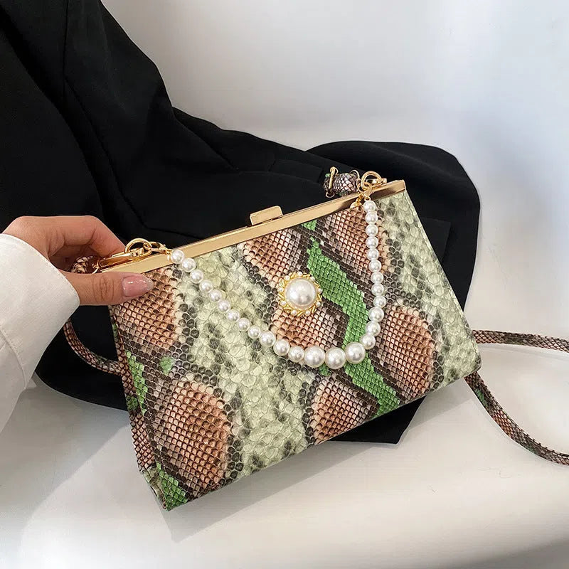 Hard PU evening bag in snake pattern with pearl-chain detail and stitching, available in six colours