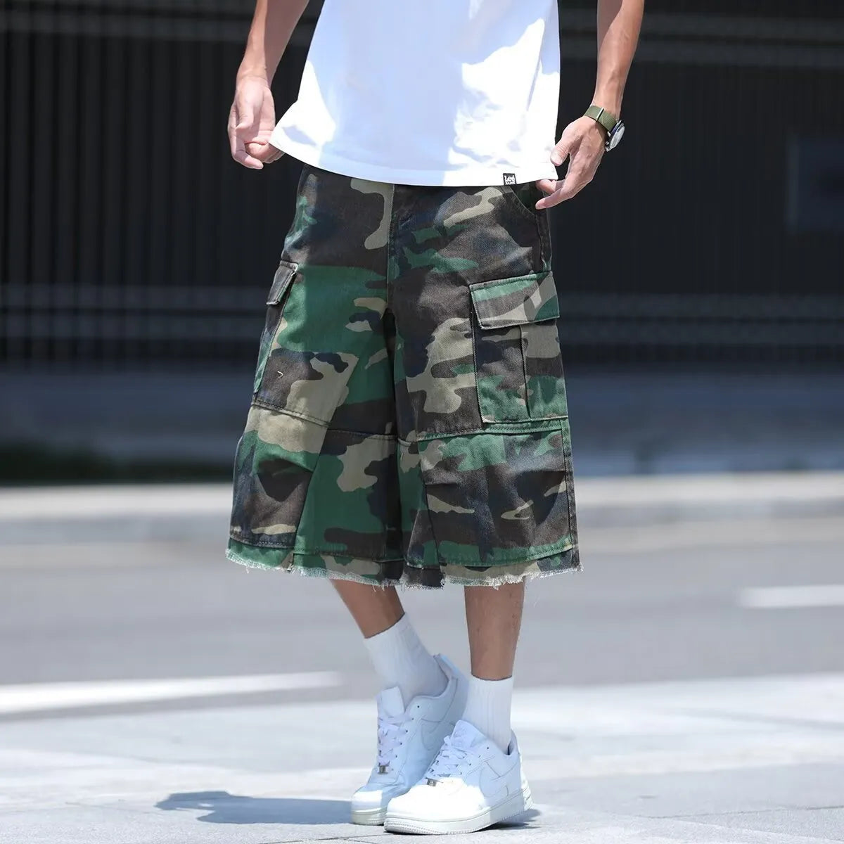 American style retro workwear loose camouflage shorts in cropped length on a neutral background.