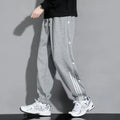 Men's loose grey sweatpants with ankle ties and a drawstring waist
