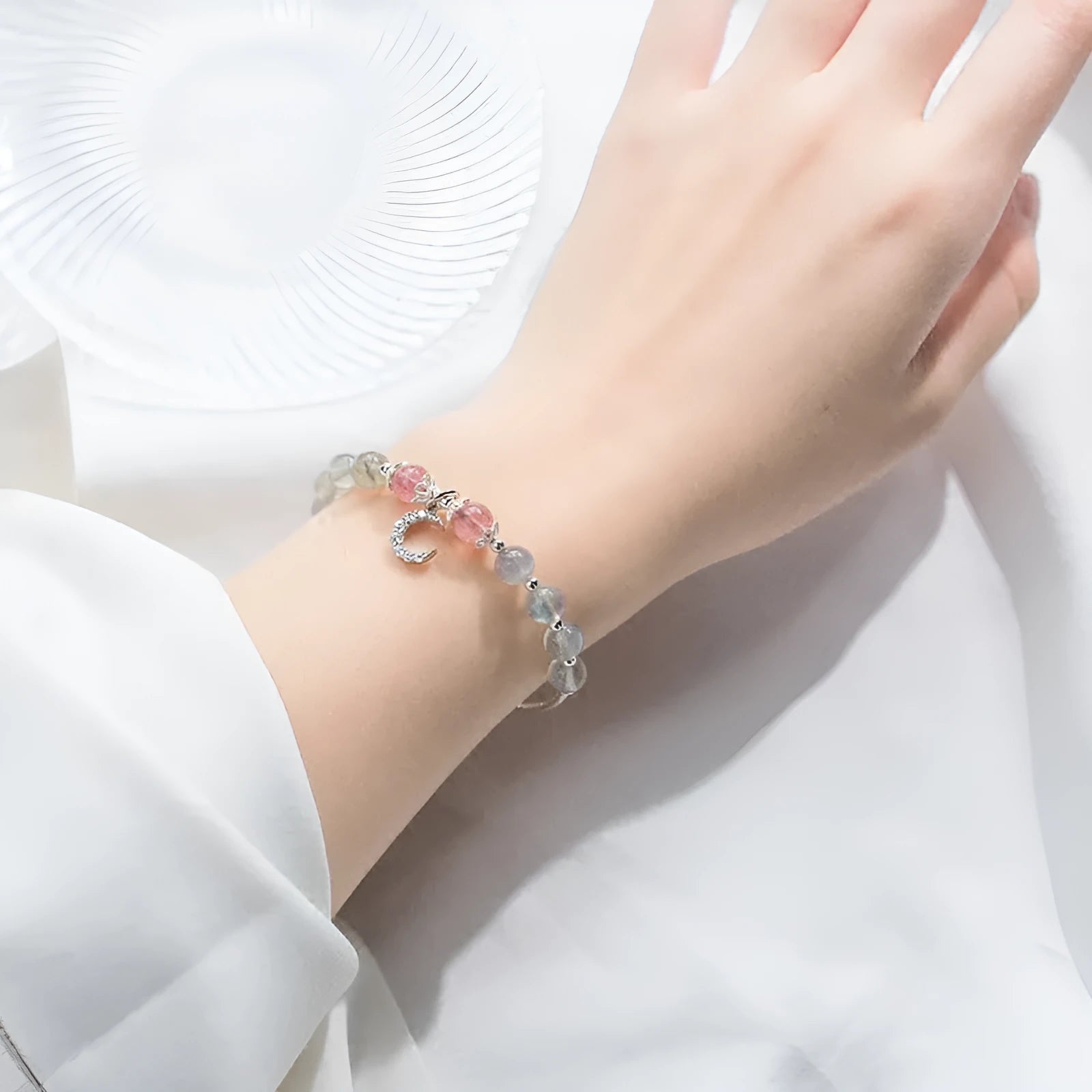 Handmade silver-toned bracelet with a blue-grey 6mm moonstone bead, small crescent moon charm, and clear crystal on an adjustable chain.
