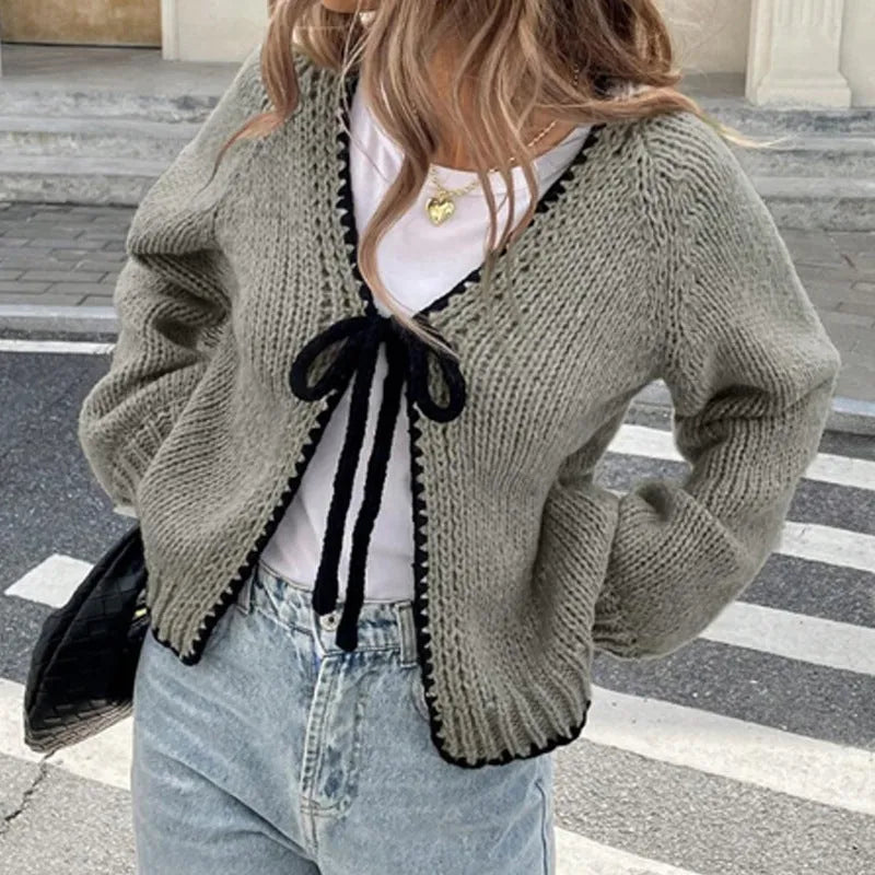 Women's grey lace-up cardigan with crocheted flowers on the front and loose long sleeves.