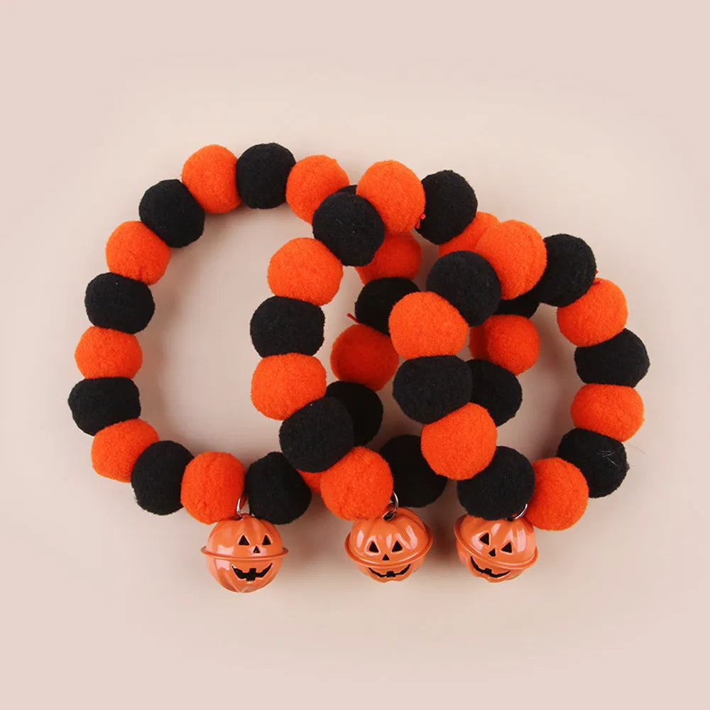 Orange Halloween cat collar with pumpkin print, breakaway buckle, and bell on a fabric band.