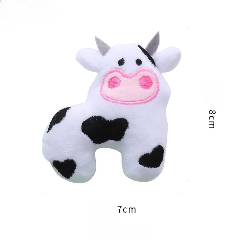 Plush cat toy shaped like a cow, crocodile, or parrot on a plain background.