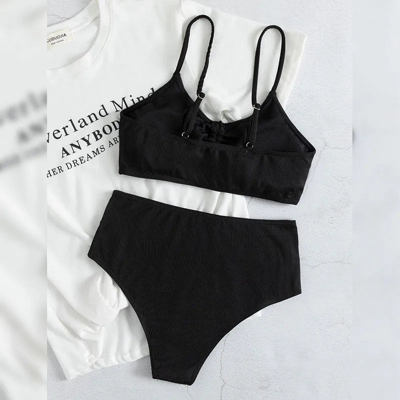Black women's bikini swimsuit with sling split style and high waist shorts.