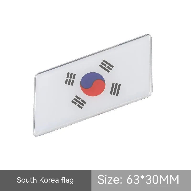 Aluminium national flag car sticker in a parallelogram shape measuring 6.3 by 3 centimetres.