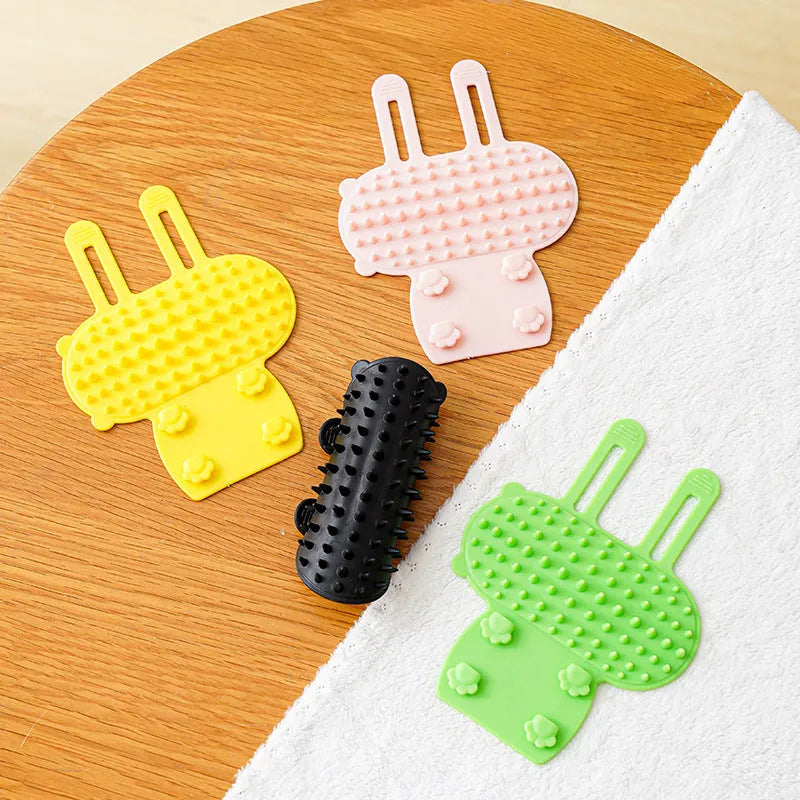 Silicone cat grooming comb scratcher with adjustable strap mounted on a table leg