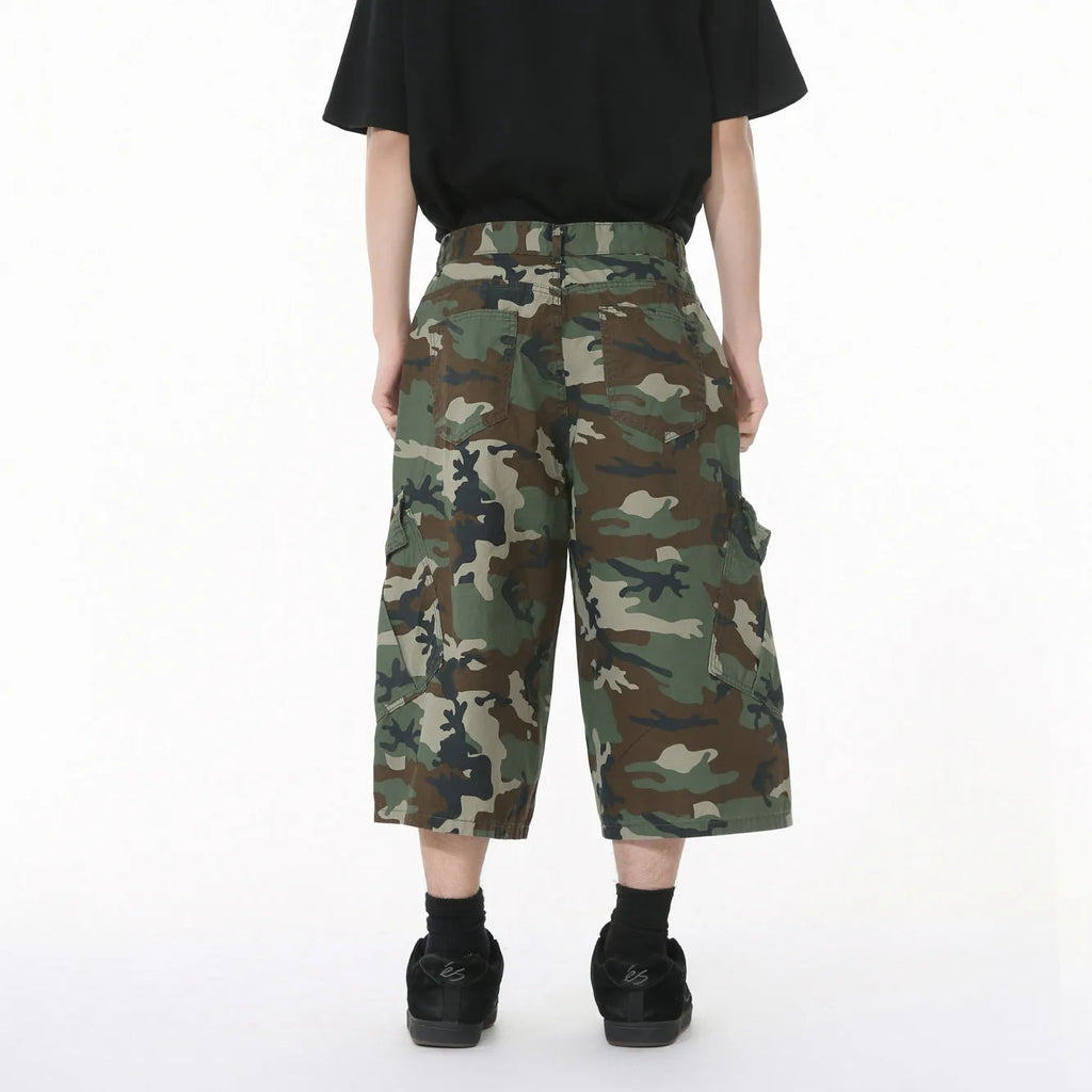 Men's camouflage-coloured cotton jeans with wide loose legs, cropped length, and side pockets on a plain background.