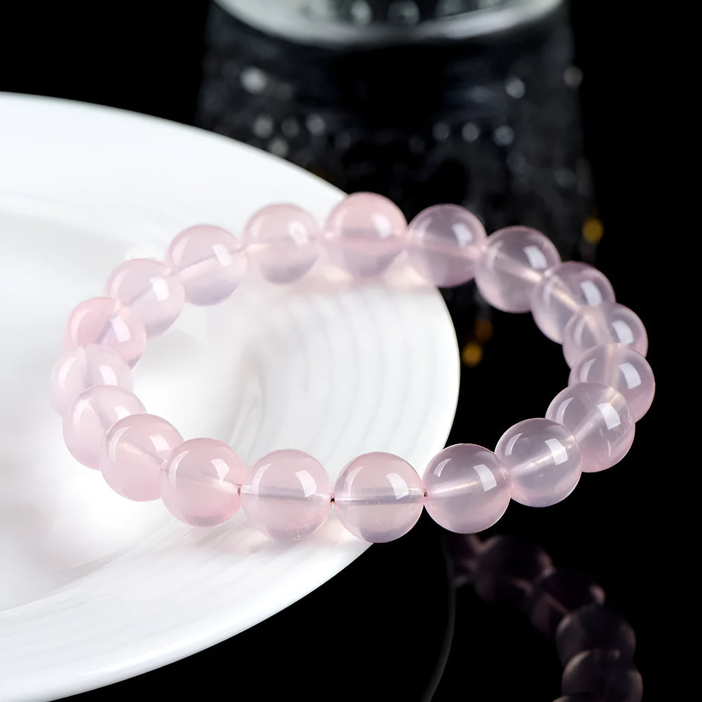 Women's crystal bracelet with round polished beads in pink, showing size options from 6mm to 22mm diameter