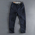 Men's khaki cotton work trousers featuring a buckle belt closure and a three-dimensional cut.