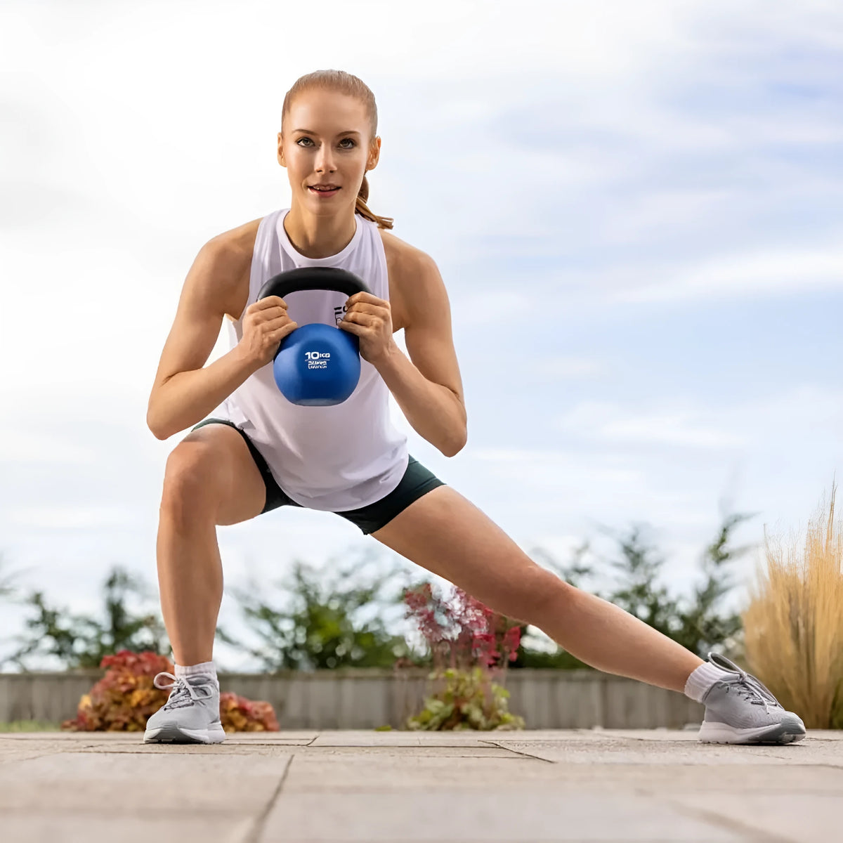 Blue solid cast iron teapot-shaped dumbbell on a plain background