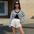 Black and white striped long-sleeved sweater worn as a pullover with an exposed navel style detail.