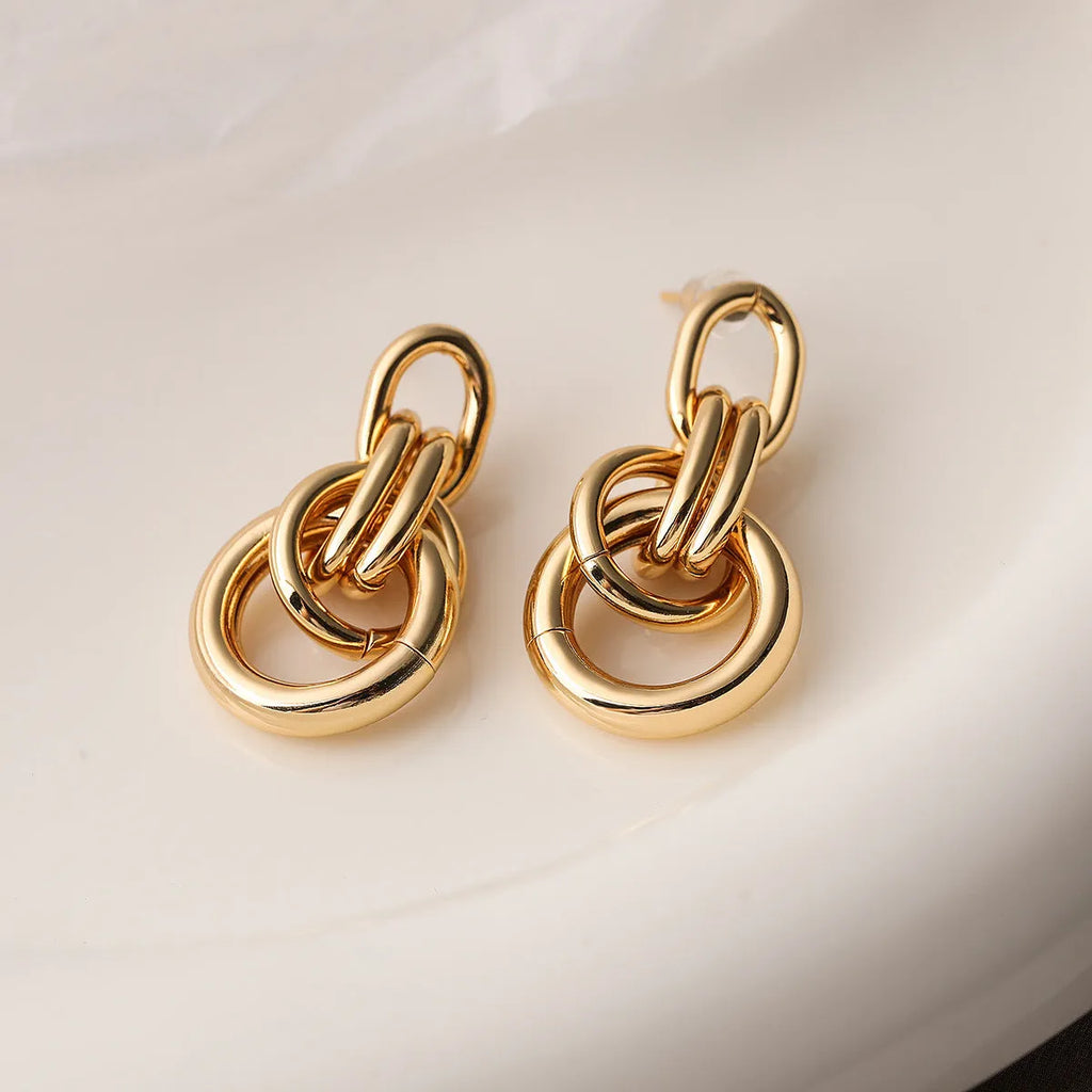 Geometric gold earrings with irregular design elements on copper base with gold electroplating