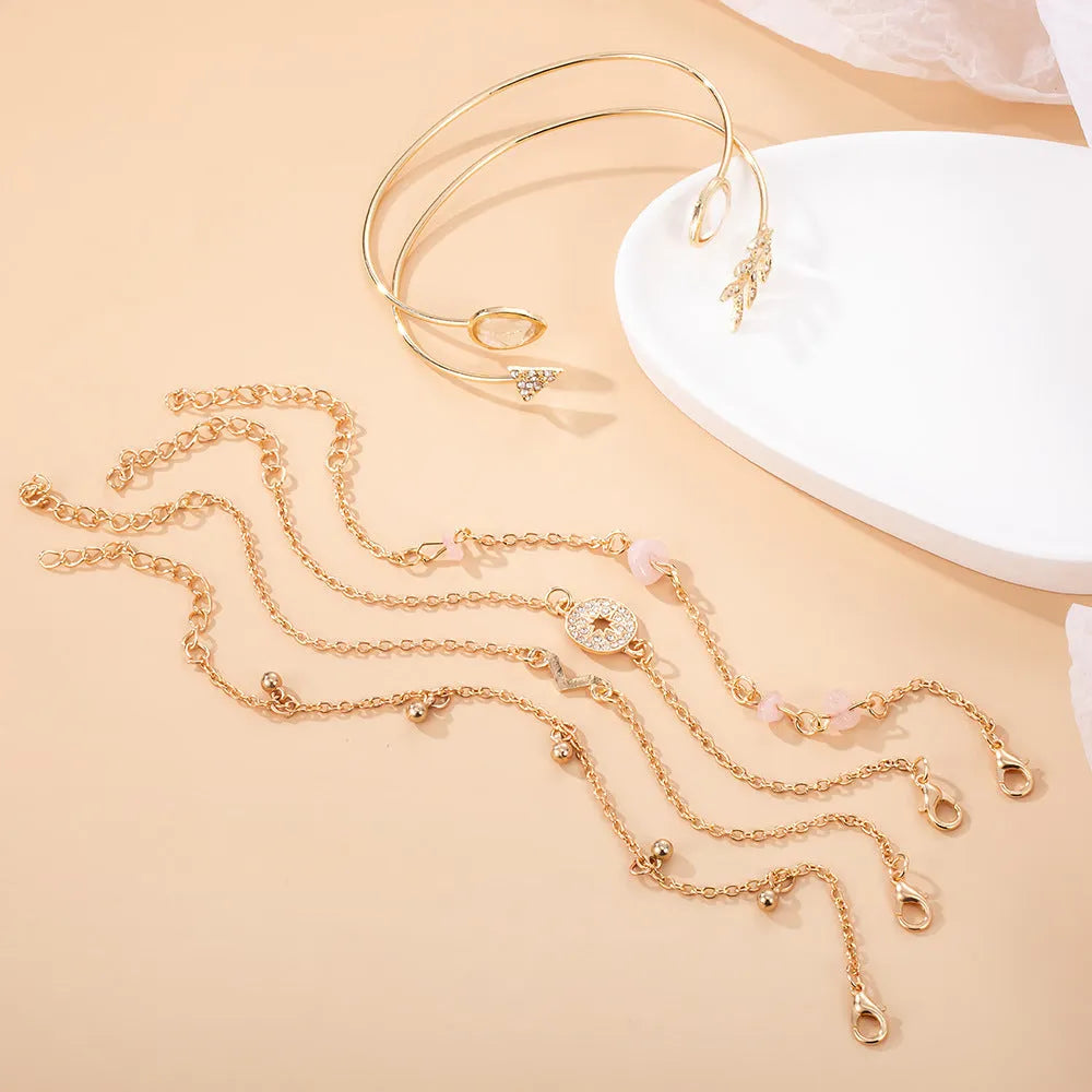 Gold-coloured six-piece bracelet set with arrow and water drop shapes featuring spot drill detailing