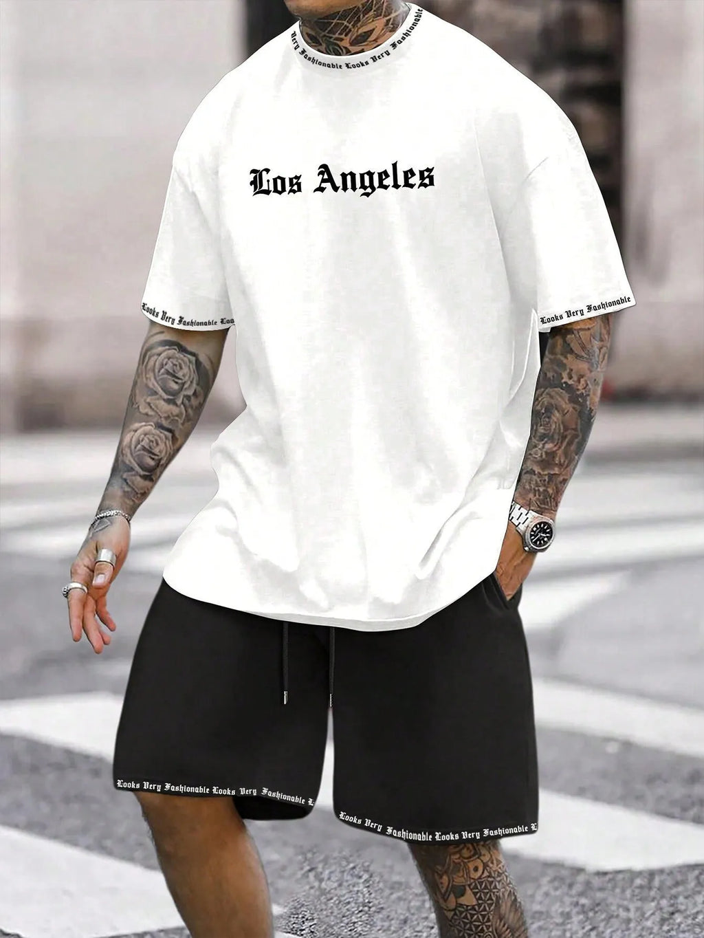 Man wearing a grey short sleeve athletic top and matching shorts from a polyester sportswear set.