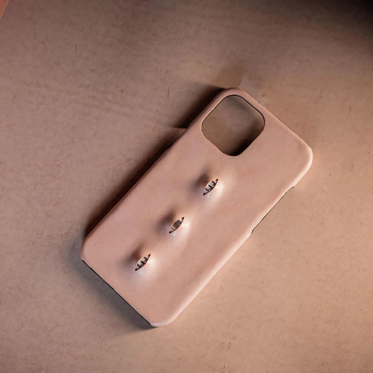 Pink eye-shaped handmade iPhone case in waxed vegetable-tanned cowhide with PC bottom case