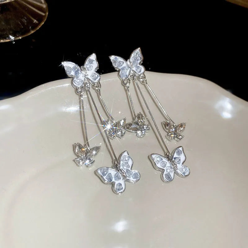 Silver butterfly tassel earrings with blue rhinestone and crystal detail, about 5.7cm long