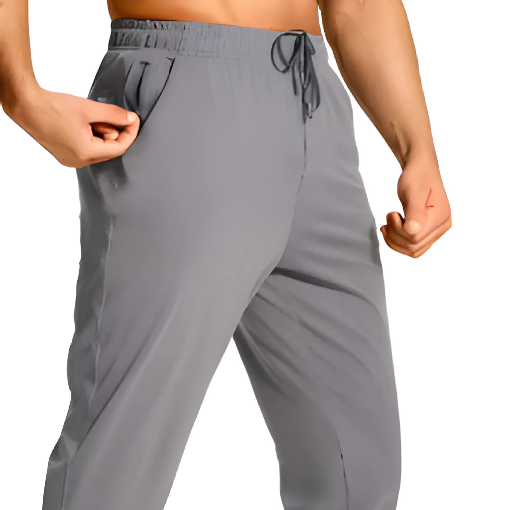 Man wearing loose fit solid colour casual polyester trousers in a leisure setting.