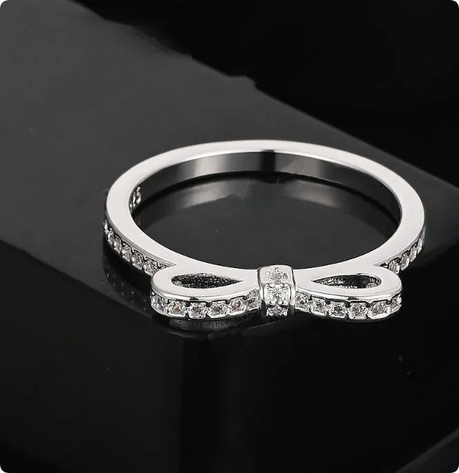 Silver bow-shaped ring with rhinestone zircon crystal decoration on model finger
