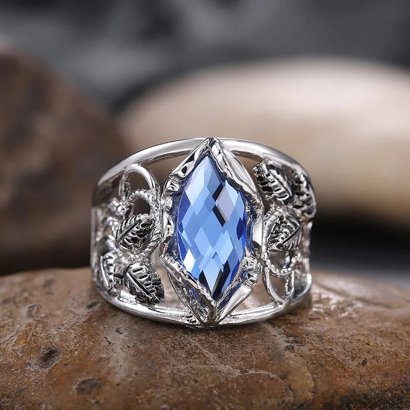 Women's horse eye-shaped blue crystal alloy ring on a hand, showing geometric design.